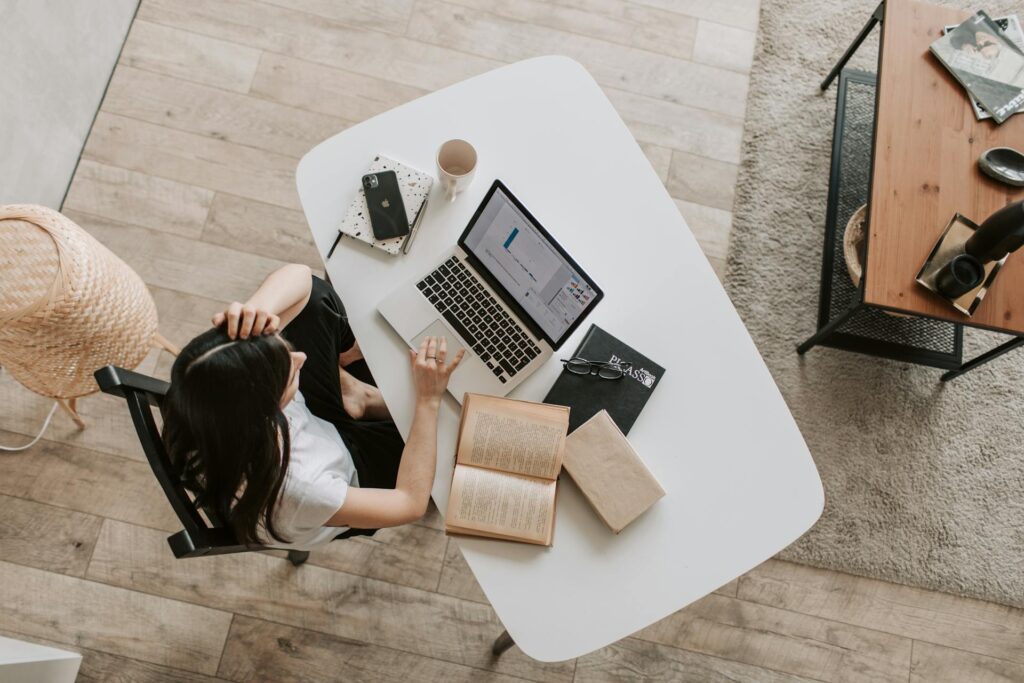 Young lady using laptop at table in modern workspace